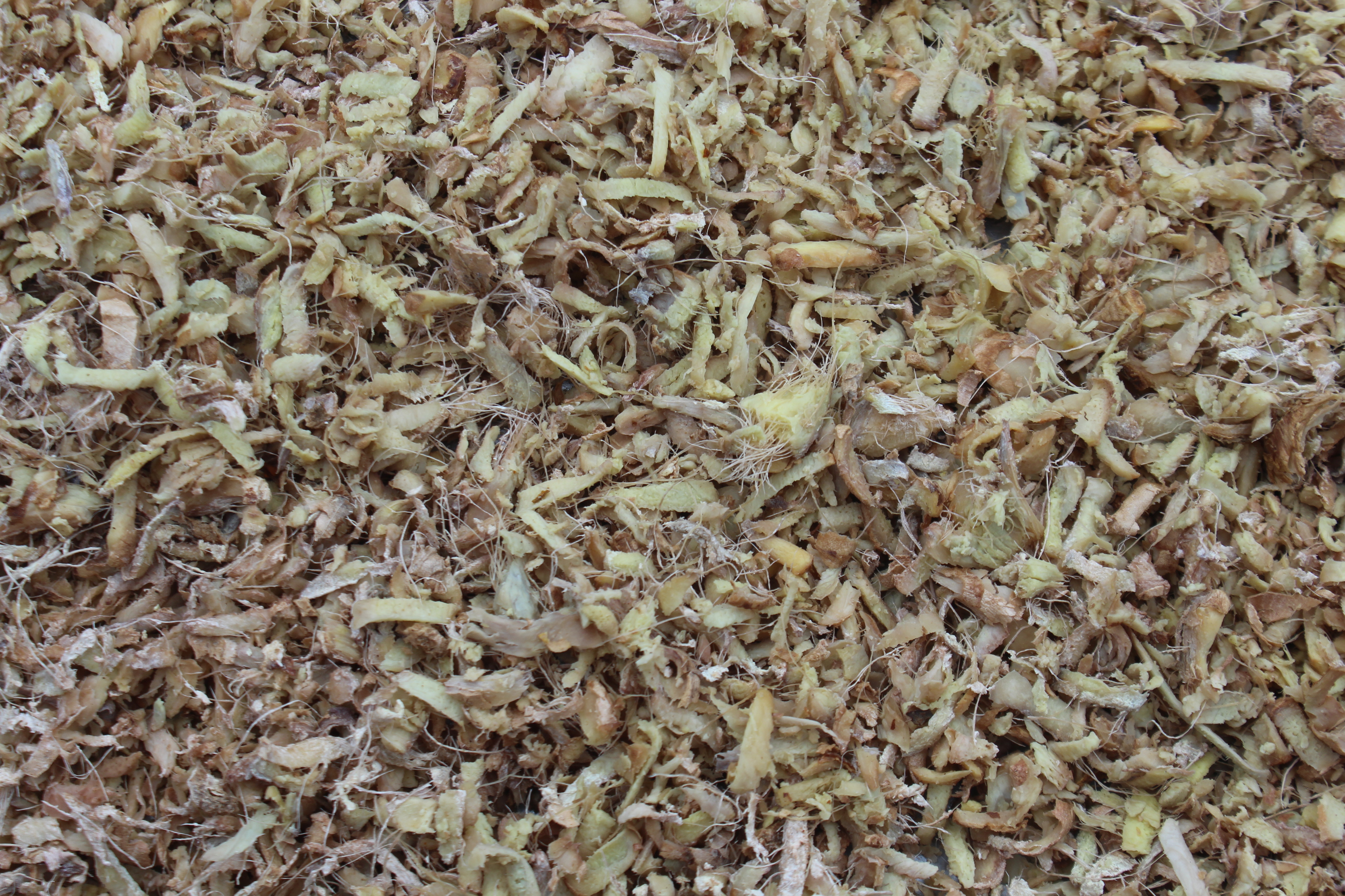 Close-up view of dried, shredded plant material with a mix of light and dark brown hues.